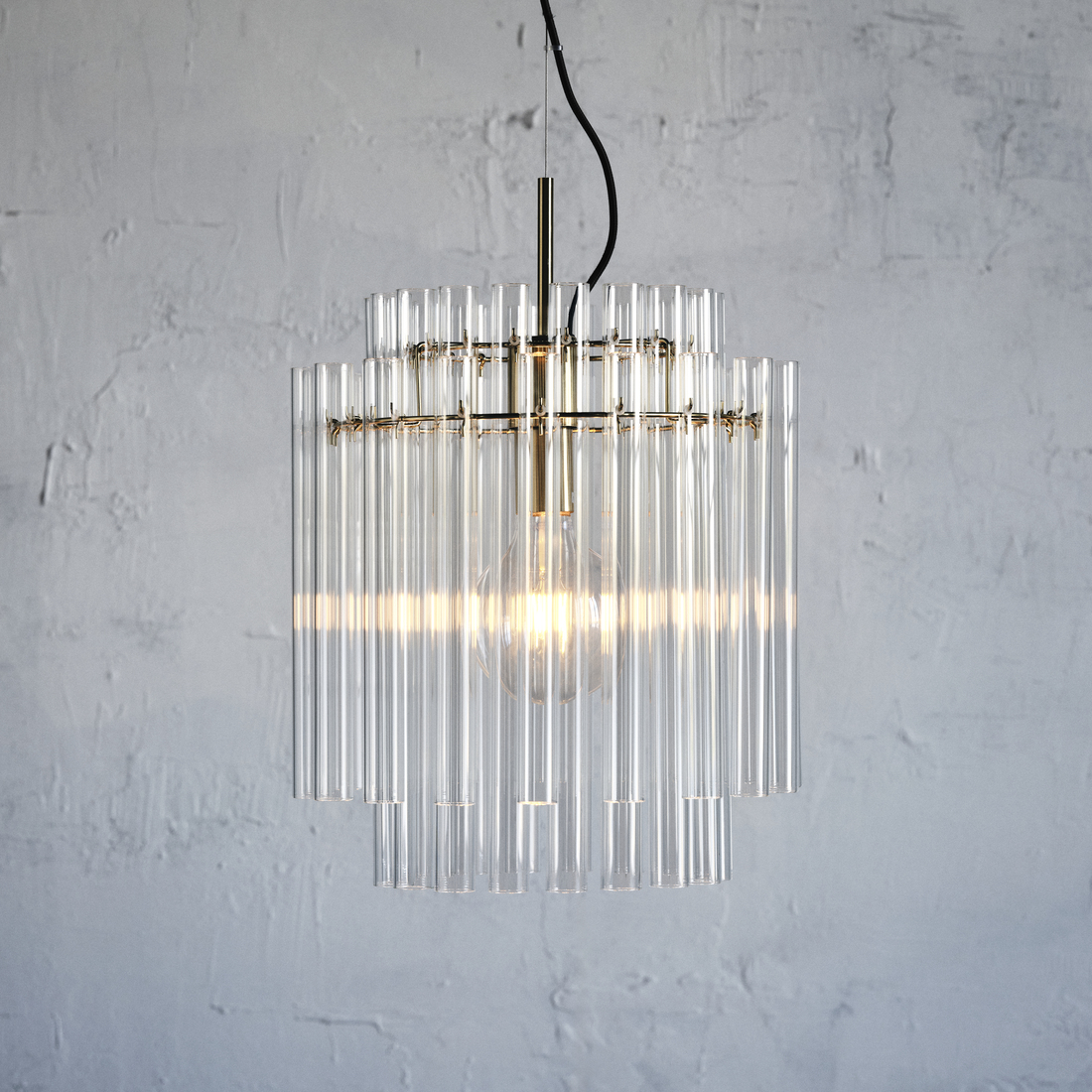 Elegant pendant light featuring vertically arranged clear glass tubes with gold accents against a textured light wall.
