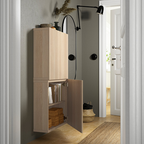 Light wood cabinet, wall-mounted with doors ajar, revealing organized items. Adjustable hinges and removable doors.