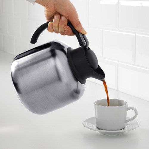 Verter el café de una jarra aislada en una taza.