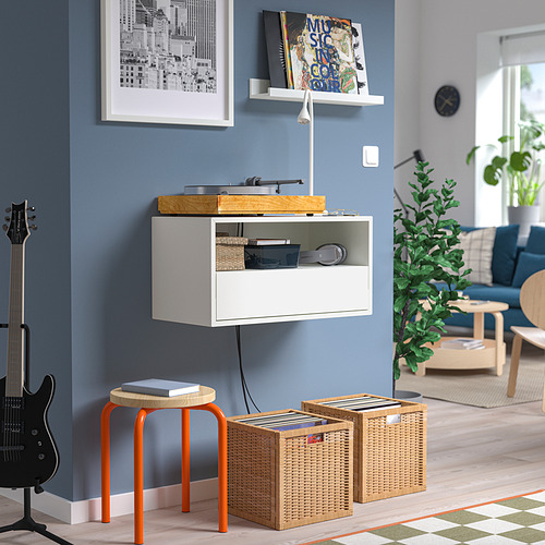 Sala de estar moderna con estante de pared EKET, tocadiscos, taburetes naranjas, almacenamiento de vinilo y guitarra.