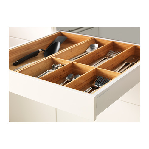 Organized kitchen drawer with bamboo dividers holding utensils.