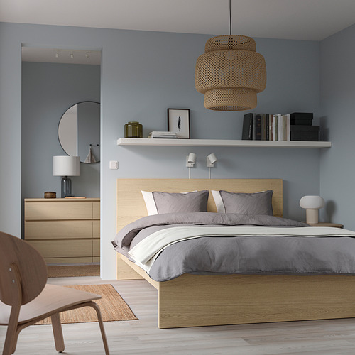 Dormitorio moderno con cama MALM, lámpara colgante, tocador, espejo, paredes azules, pisos de madera, silla beige.