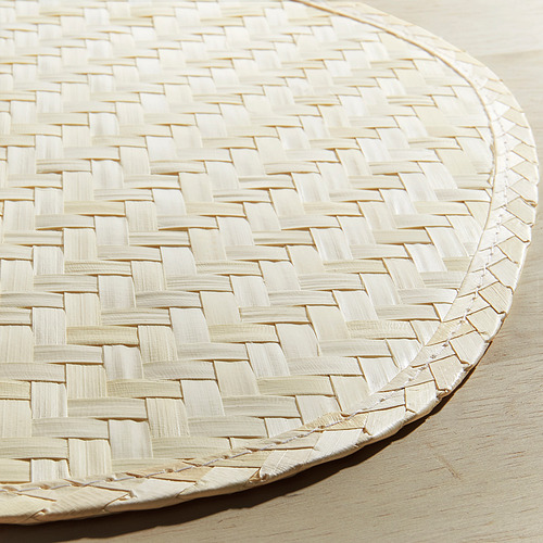 Mantel individual de marfil tejido a mano con un intrincado patrón de celosía, elaborado con hoja de palma, que muestra una textura y calidad artesanales.