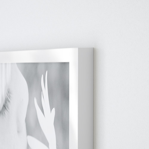 Esquina de un marco de fotos VÄXBO blanco. Muestra bordes limpios y nítidos y un diseño elegante. Adosado a una pared blanca lisa, resaltando su estilo minimalista.