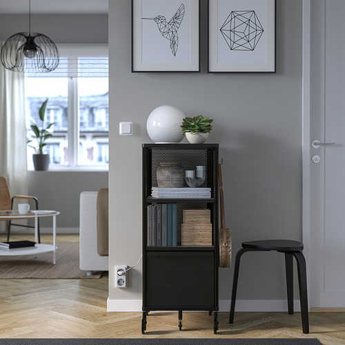 Salón moderno con estantería, libros, decoración, planta. Arte enmarcado, puerta, taburete, sofá, mesa de centro, lámpara.