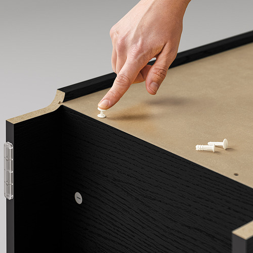 Colocación manual de alfiler de madera sobre tablero de corcho de las estanterías BILLY. Librería negra, corcho natural, pin blanco.