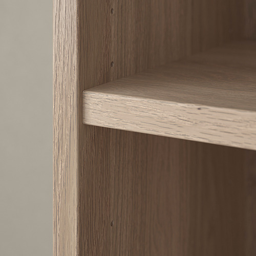 Primer plano de la esquina de una estantería de madera, que muestra un acabado suave y una ligera textura de vetas de madera.