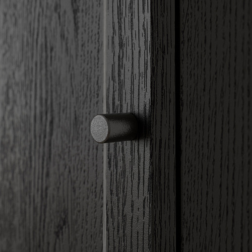 Un primer plano de una puerta de madera oscura veteada con un simple tirador metálico cilíndrico, que muestra su superficie texturizada y su acabado de alta calidad.