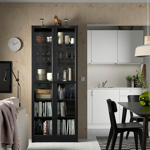 Habitación moderna con librería BILLY, platos, vasos, libros, reloj.