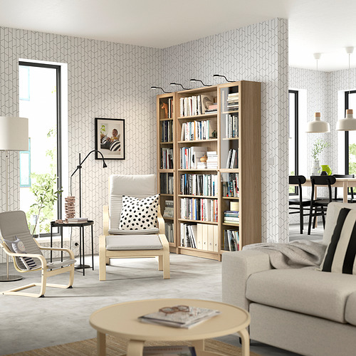 Moderno salón con librería, sofá, sillones y lámpara.