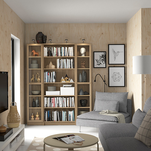 Sala de estar moderna con una gran estantería BILLY, sofá gris, mesa de café y televisión.