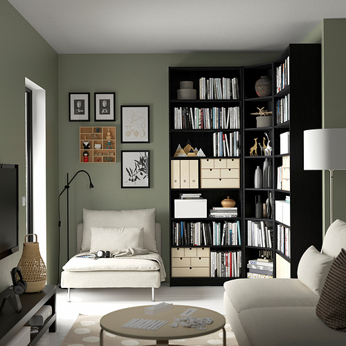Sala de estar moderna con estantería BILLY verde, sofá blanco y mesa de centro. La lámpara de pie crea un acogedor rincón de lectura.