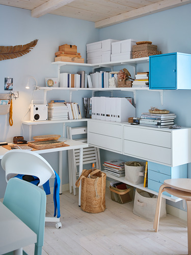 Oficina en casa bien organizada con muebles blancos y azules. Las estanterías de BERGSHULT contienen libros, cajas, cestas y contenedores. Pared azul claro, suelo de madera.