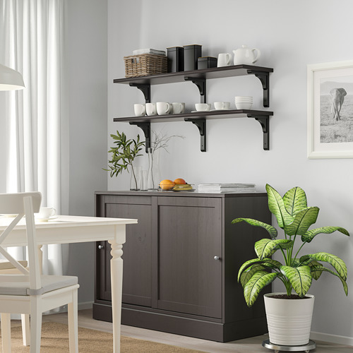 Comedor moderno con mueble de madera oscura, sillas blancas, plantas y estantes de vajilla.