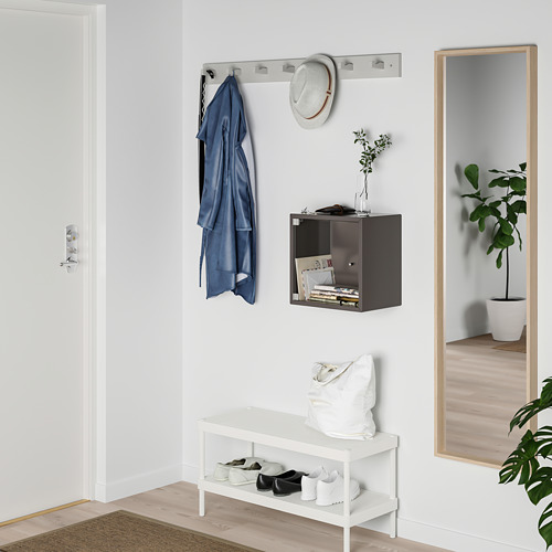 Pequeña puerta de vidrio blanco para la exhibición de cubos EKET, que encaja perfectamente sobre un banco en una entrada ordenada.