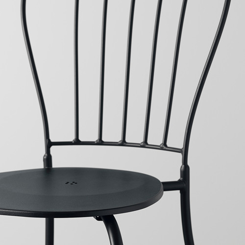 Silla moderna de metal negro, diseño elegante. Asiento circular con orificio de drenaje, patas robustas, ideal para uso en exteriores.