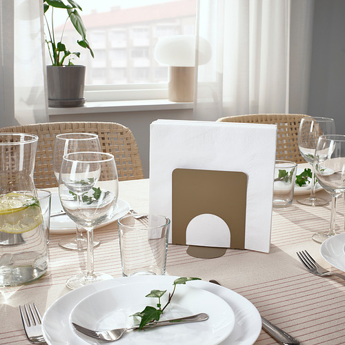 Mesa con vasos, platos y cubiertos. Servilletas cuidadosamente sujetas en un soporte.