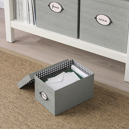 Tres cajas de almacenamiento de tela etiquetadas: al abrir, una muestra las carpetas, cerca del piso de madera y el estante.