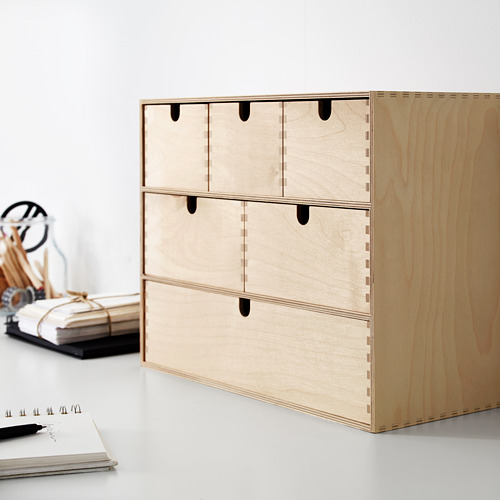 Mini cómoda MOPPE de madera de color claro con múltiples cajones pequeños, cuidadosamente organizados con un diseño moderno y sencillo.