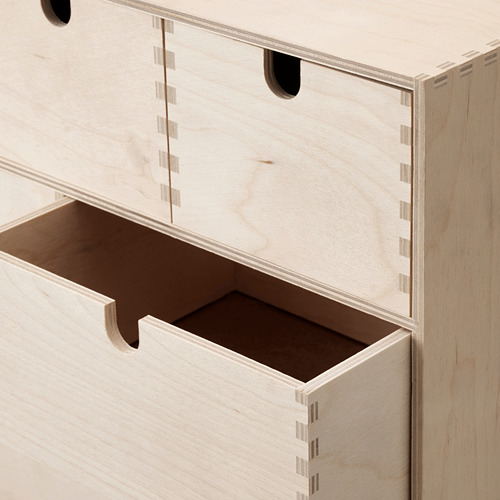 Cómoda de madera de color claro con múltiples cajones. Diseño robusto y bien elaborado, acabado con uniones precisas.