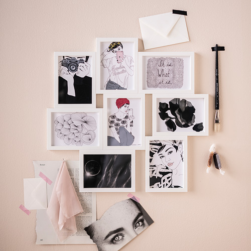 Una pantalla de pared con marcos de plástico blanco VÄXBO en varias formas, que contienen impresiones artísticas y fotos, con un pincel y letras.