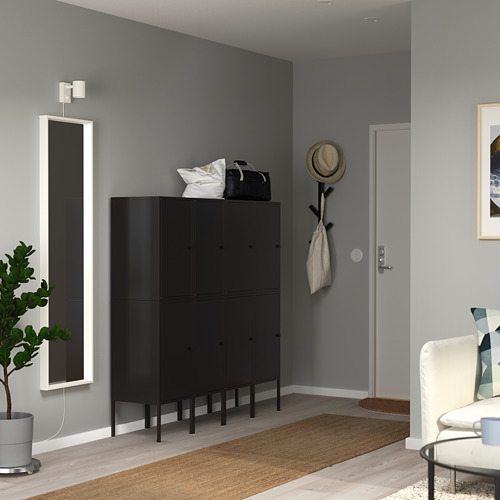 Mueble de almacenaje LIXHULT negro en pasillo con espejo, alfombra, silla.
