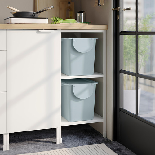 Dos contenedores TRÖSKNING azul claro almacenados en un armario blanco, ideales para la clasificación de residuos y la decoración.