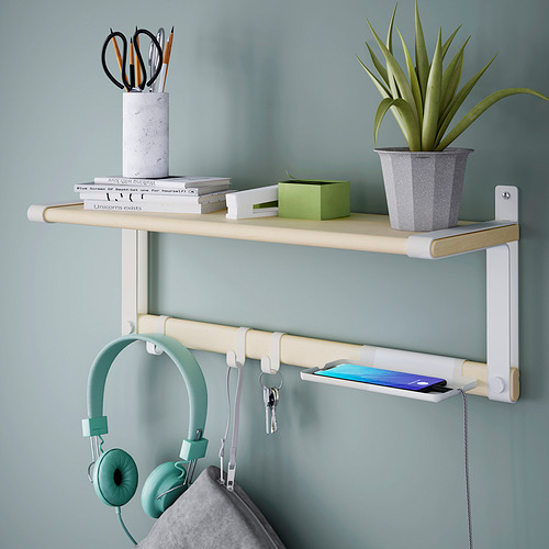 Estante montado en la pared con ganchos que sostienen auriculares y llaves, bandeja con un teléfono y planta en maceta con libros y artículos de papelería en la parte superior.