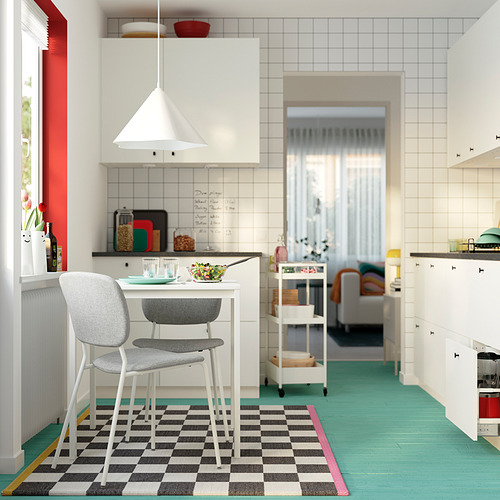 Cocina moderna con mesa blanca, sillas grises, ensaladera. Diseño minimalista, luz colgante, suelo verde.
