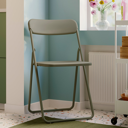 La silla plegable gris VIHALS, elegante y compacta, encaja perfectamente en una habitación moderna.