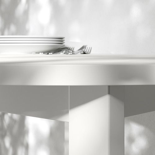 Mesa limpia y moderna con platos y cubiertos cuidadosamente apilados, que muestran un diseño elegante y funcional.