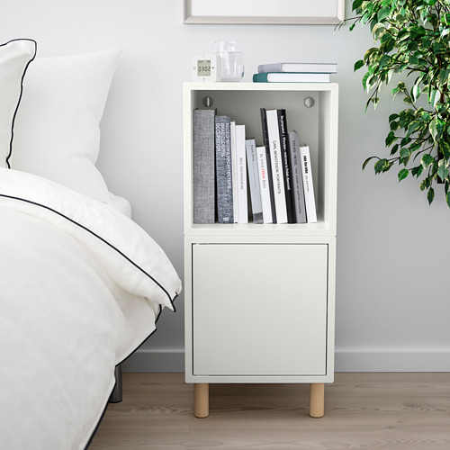 Dormitorio moderno con mesita de noche blanca al lado de la cama, sosteniendo libros, alarma y planta. Número de caracteres: 44