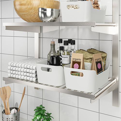 Estantes de cocina organizados con contenedores de almacenamiento, que contienen toallas, especias y artículos orgánicos.