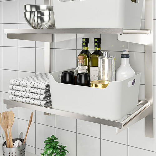 Un estante de cocina con organizador, para almacenar botellas, tazas, toallas y utensilios de manera ordenada.