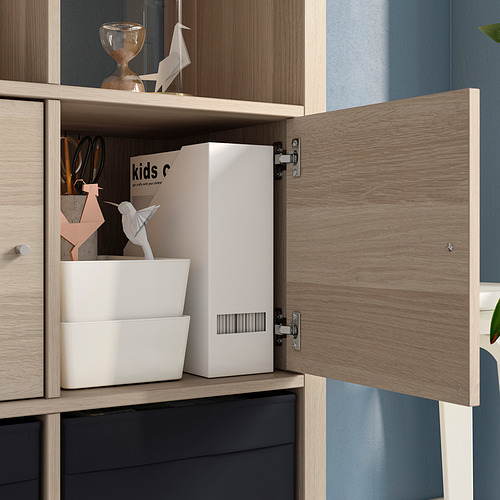Mueble KALLAX de madera con puertas abiertas, expositores, organizadores blancos y origami.