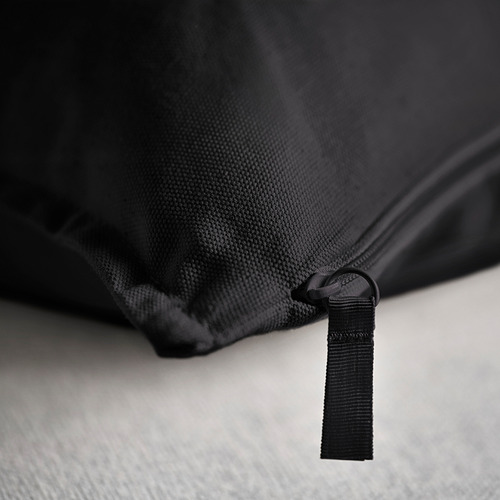 Primer plano: funda de cojín negra con cremallera de calidad, tejido texturizado, probablemente algodón.