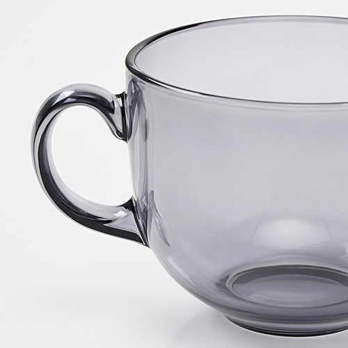 A translucent grey glass mug with a sturdy handle, showcasing sleek design and good quality.