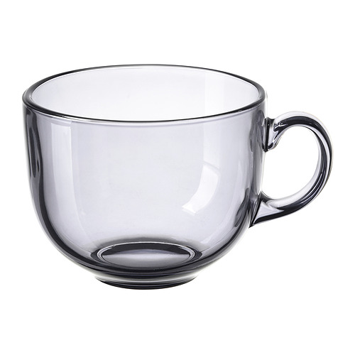 Single, transparent grey glass cup with small handle, round shape.