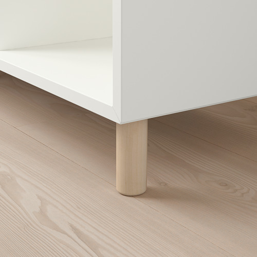 Mueble blanco con pata de madera sobre suelo de madera clara.