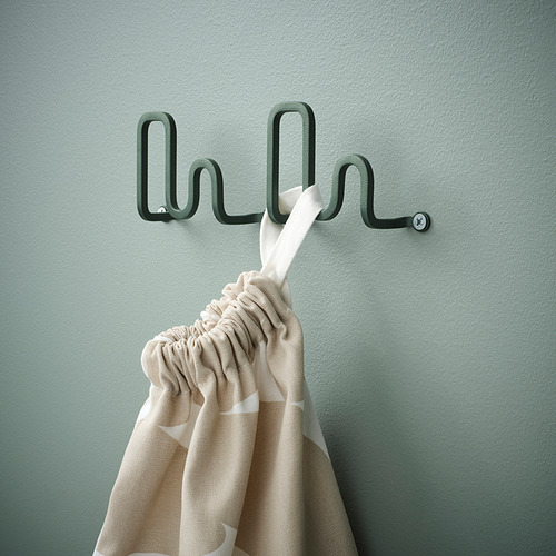 Único gancho de pared que sostiene toalla a rayas, diseño moderno, verde, montado en la pared.