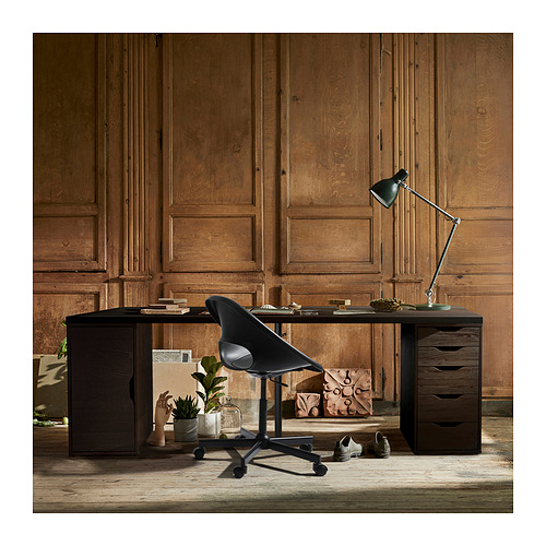 Moderna configuración de oficina en casa con escritorio de madera oscura, silla negra y lámpara ajustable contra la pared con paneles de madera.