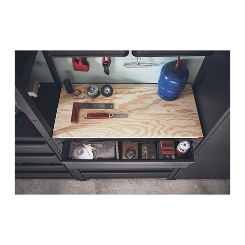 Unidad de almacenamiento de metal negro con tapa de madera, que contiene varias herramientas y artículos, incluido un cilindro de gas azul y tijeras de mango rojo.