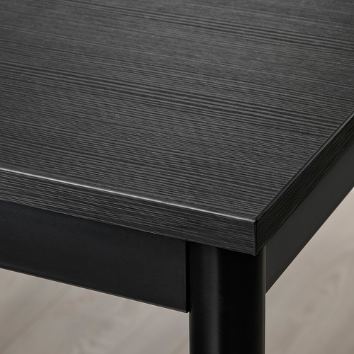 Primer plano de una mesa negra moderna. Parte superior lisa con elegante marco de metal. Diseño de alta calidad para mayor durabilidad.
