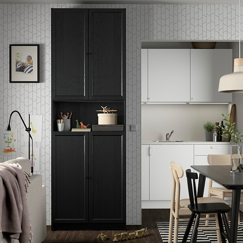 Sala de estar moderna con estantería negra BILLY, foto enmarcada, juguetes y cocina blanca con sillas de madera.
