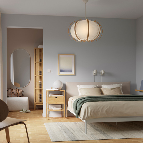 Dormitorio moderno con paredes azules, cama blanca, manta verde, suelo de madera y lámpara colgante TAGGTOFS.