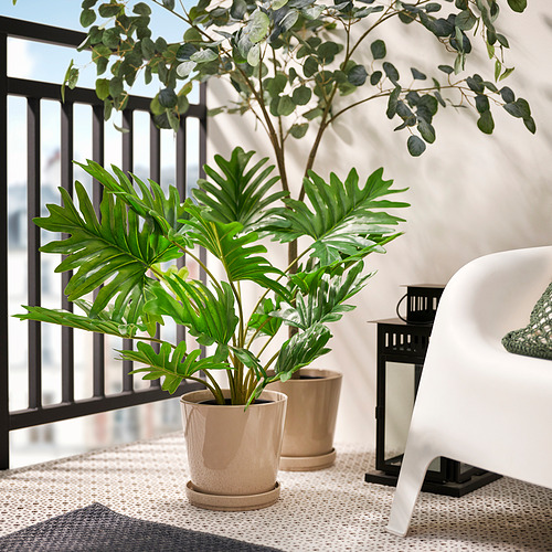 Balcón con plantas, mesa, silla y linterna de FEJKA