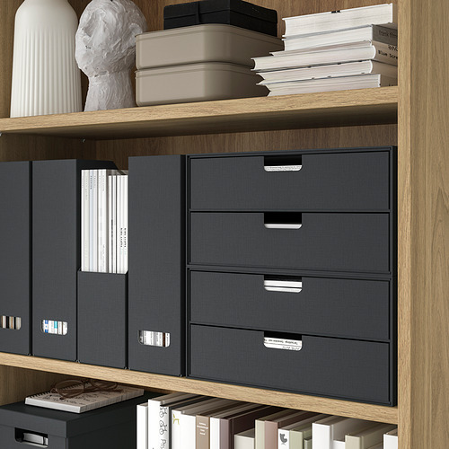 Estanterías de madera con cajones de tela gris y libros blancos.