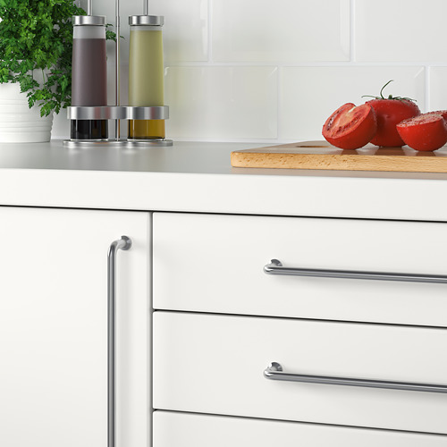 Cocina moderna con gabinetes blancos y manijas de acero inoxidable. En la encimera, hay dispensadores de aceite y tomates en rodajas.