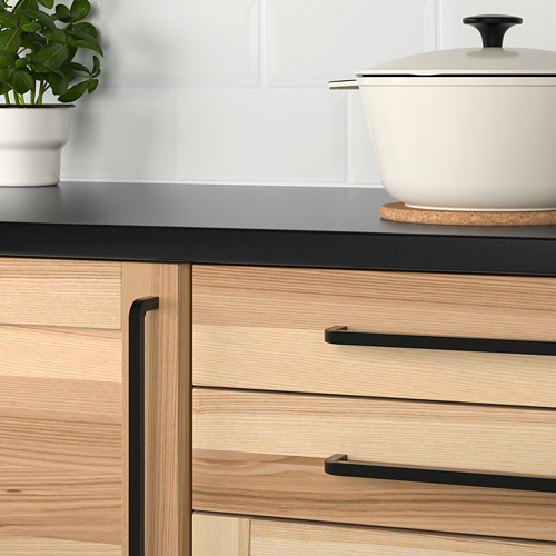 Cajones de cocina modernos con madera clara y tiradores negros.