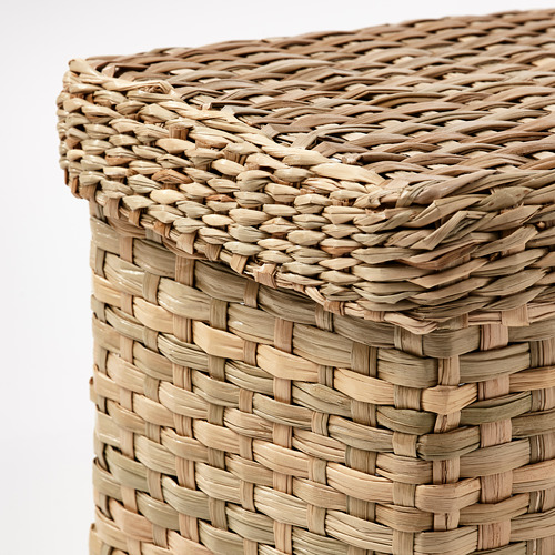 Cesta de mimbre con tapa, tejida intrincadamente, color beige natural, forma rectangular.